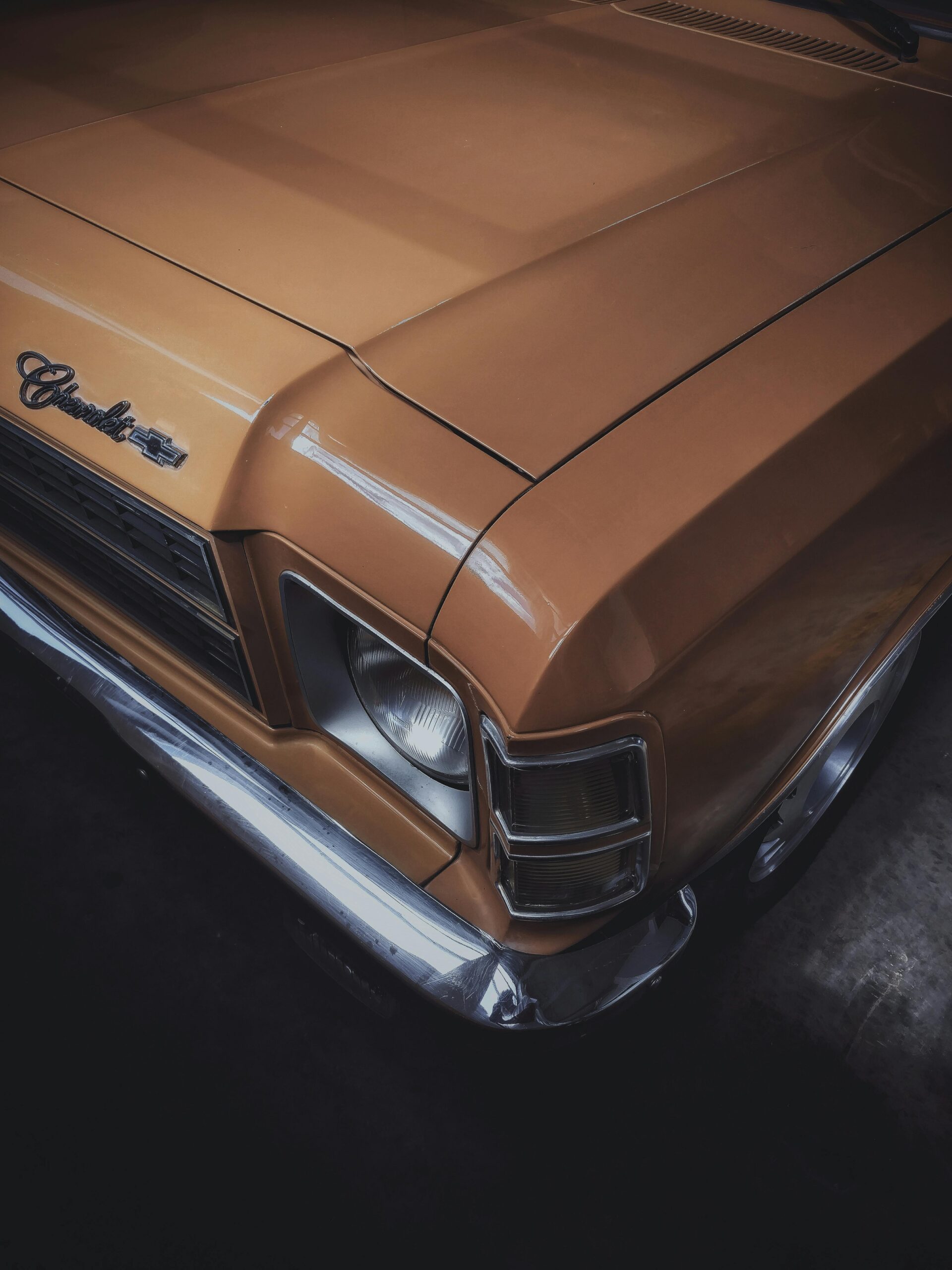 Close-up of a vintage classic car's front, showcasing its retro chrome and design elements.